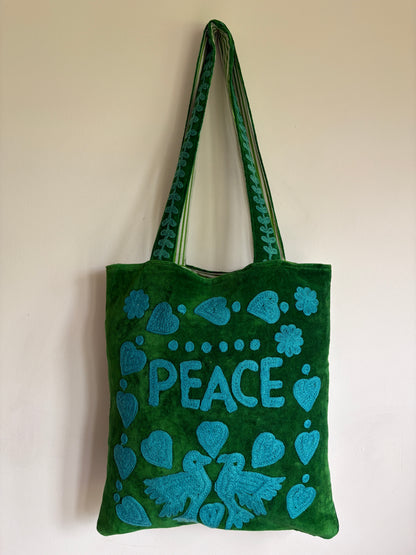 Green Suzani Velvet bag with blue hearts and 'LOVE' on a beige background