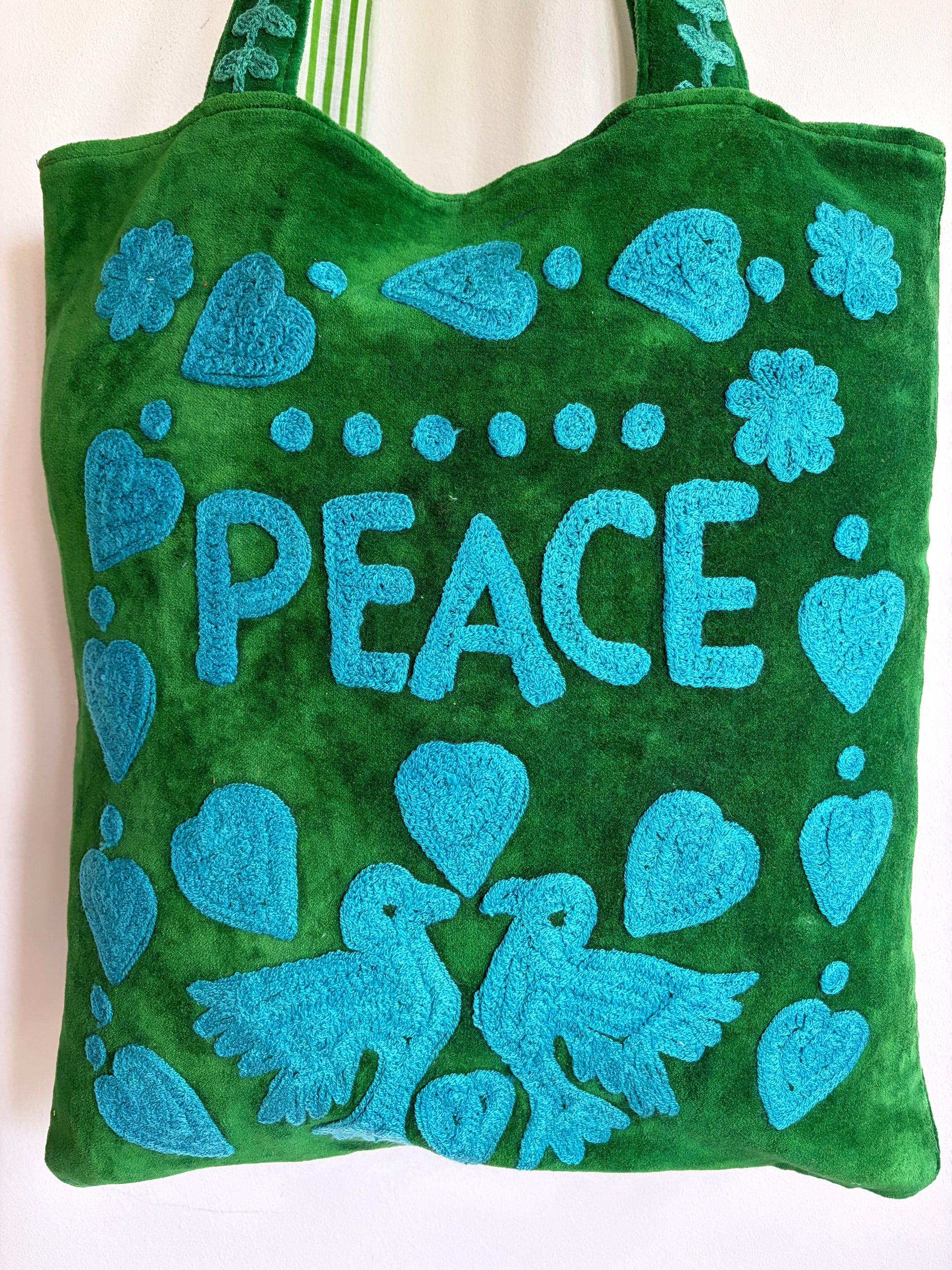 Green Suzani Velvet bag with blue hearts and 'LOVE' on a beige background