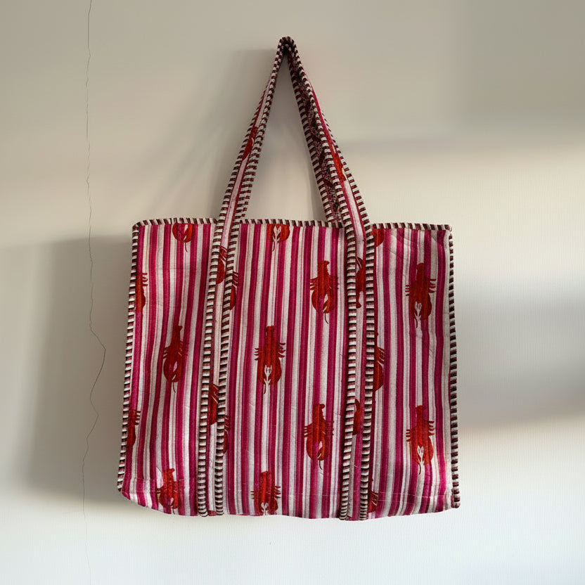 Red and white striped tote bag with red patterns on a white background