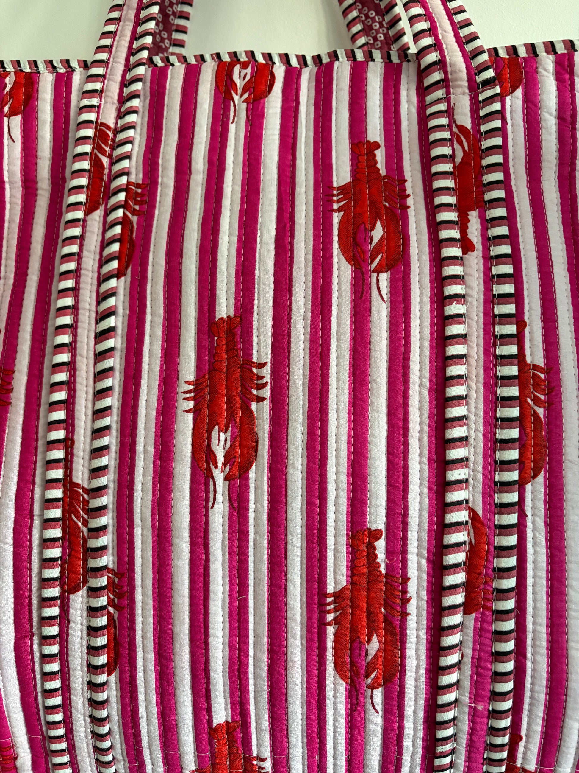 Striped fabric bag with red lobster pattern on a white background