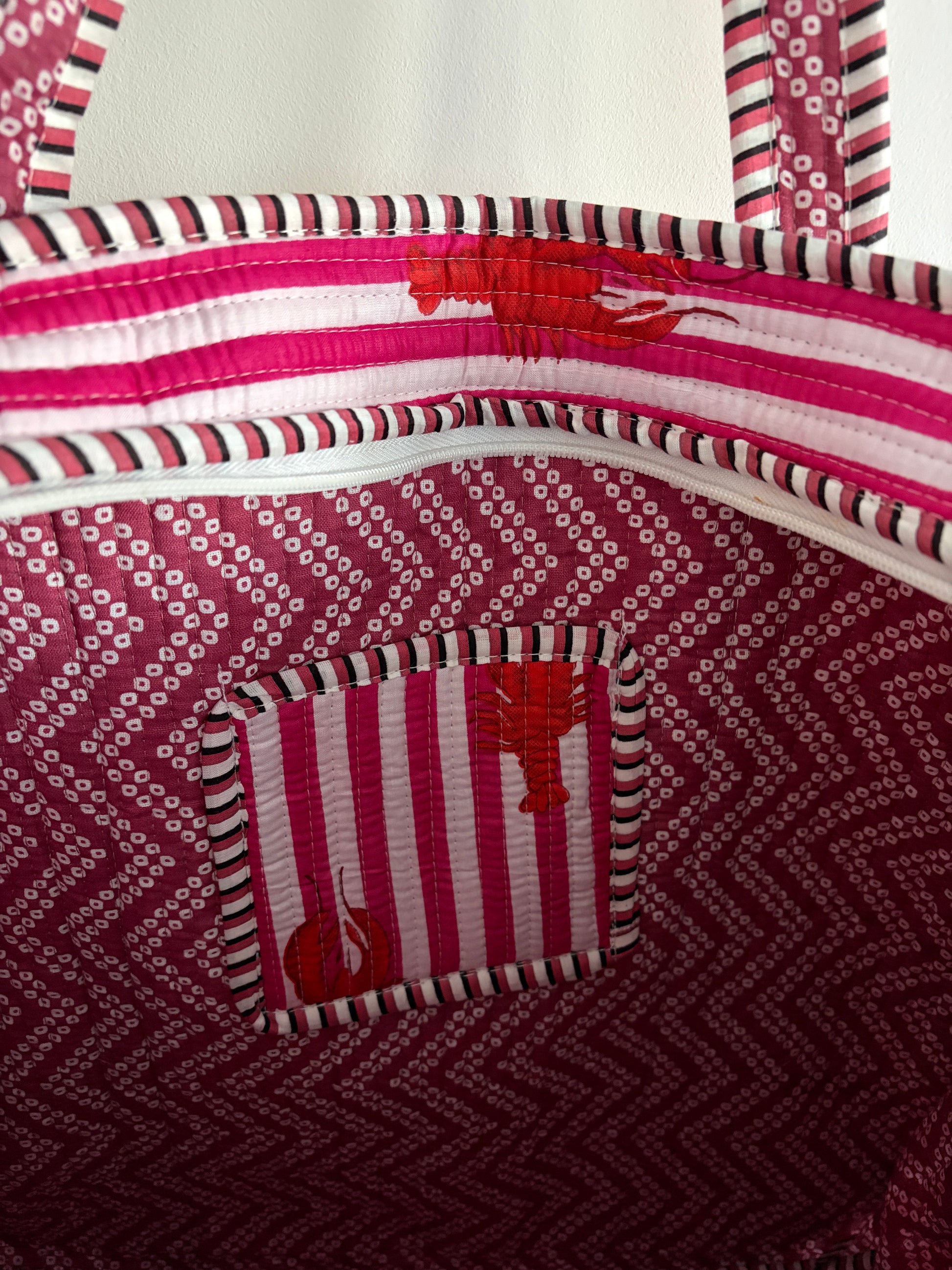 Close-up of a pink and white patterned bag with a small pocket.