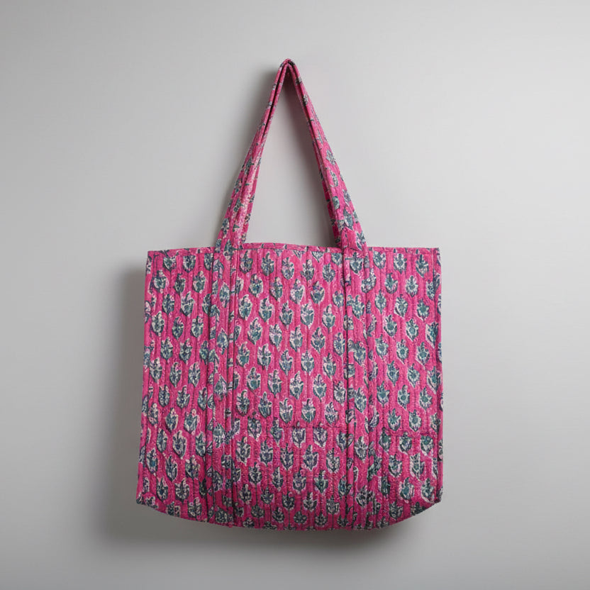Pink patterned bag on a beige surface