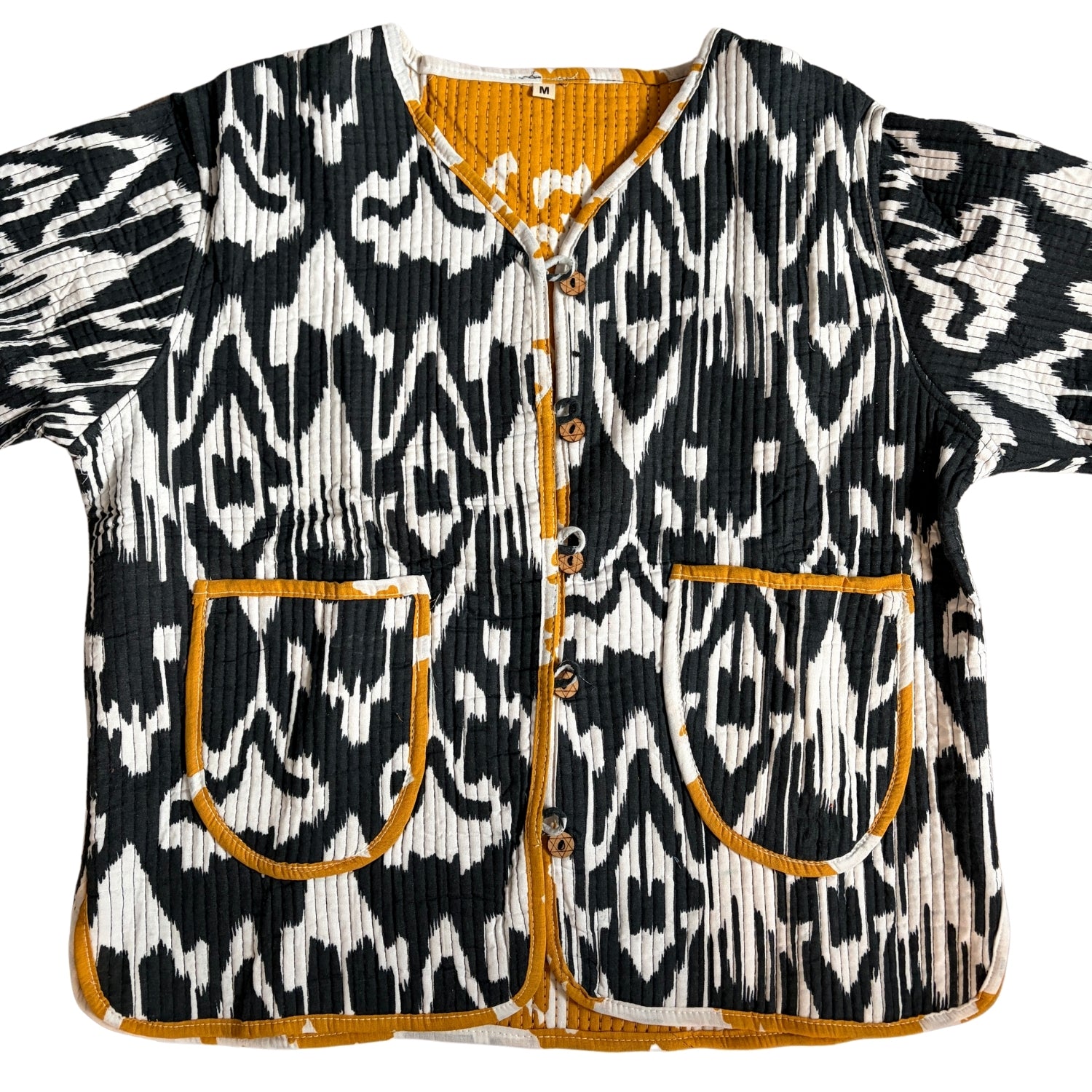 Black and white patterned jacket with orange accents on a white background