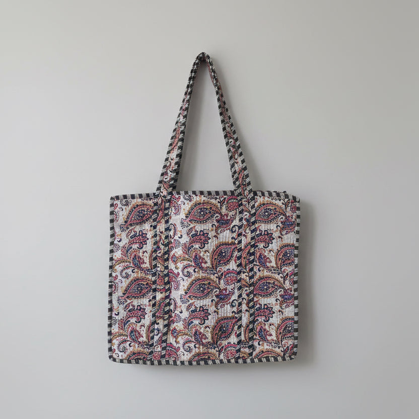 Patterned fabric on a white ladder with greenery in the background