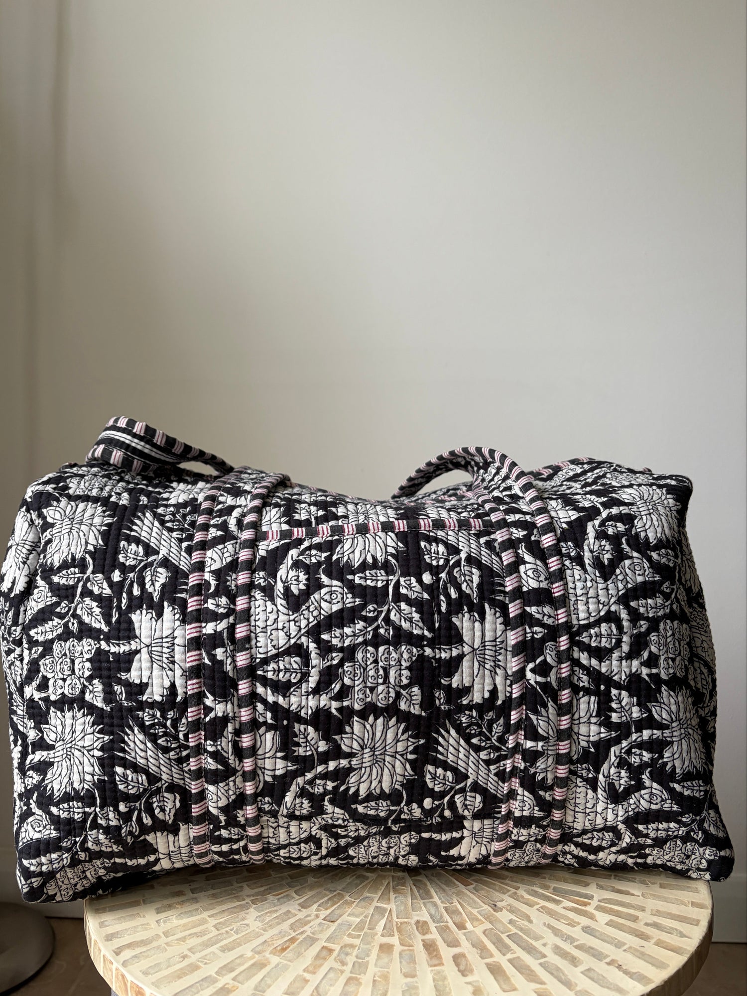 Black and white patterned bag on a chair against a plain background