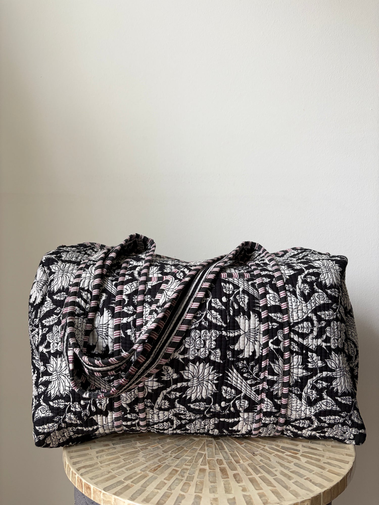 Black and white patterned fabric bag on a wooden surface
