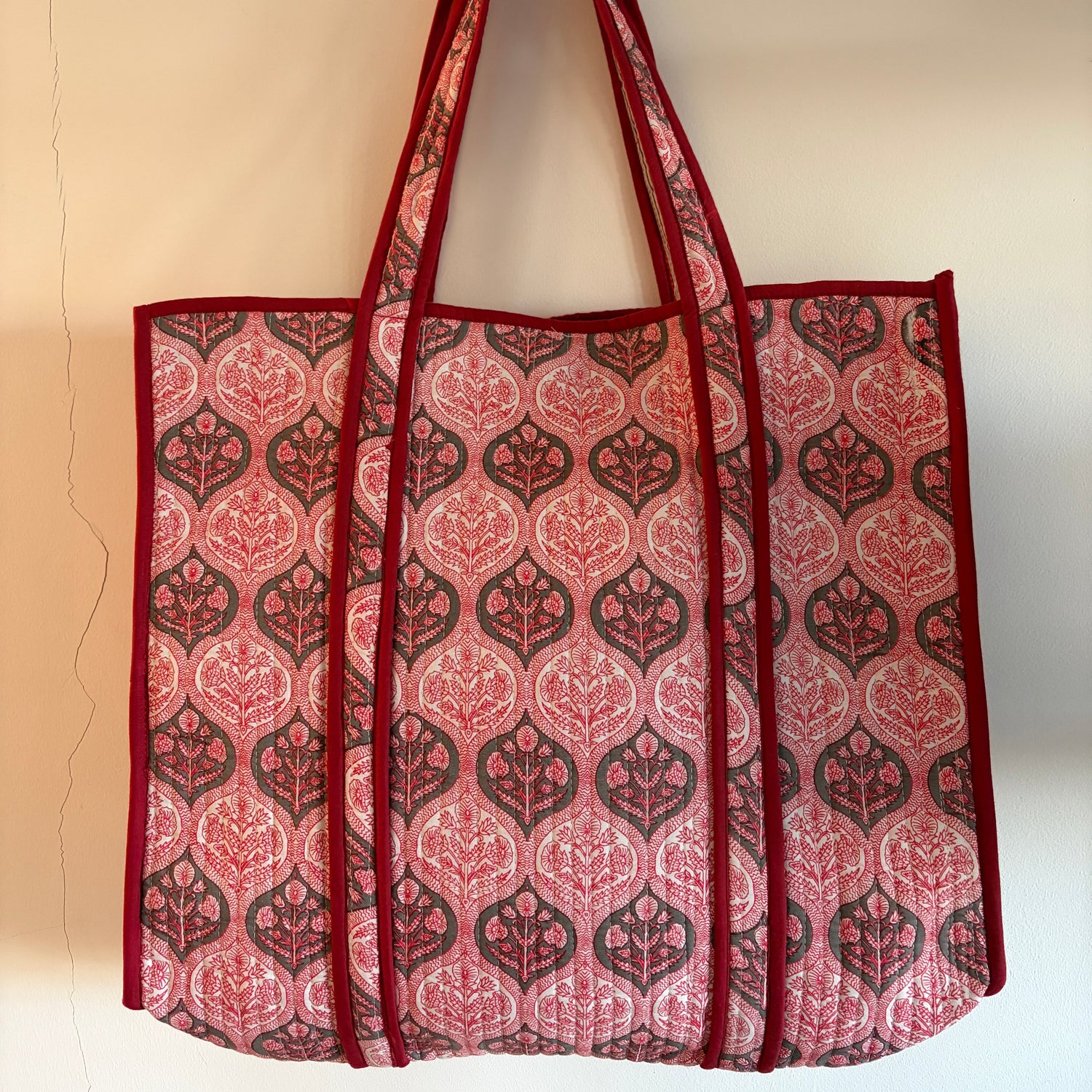 Red and brown patterned tote bag on a beige background