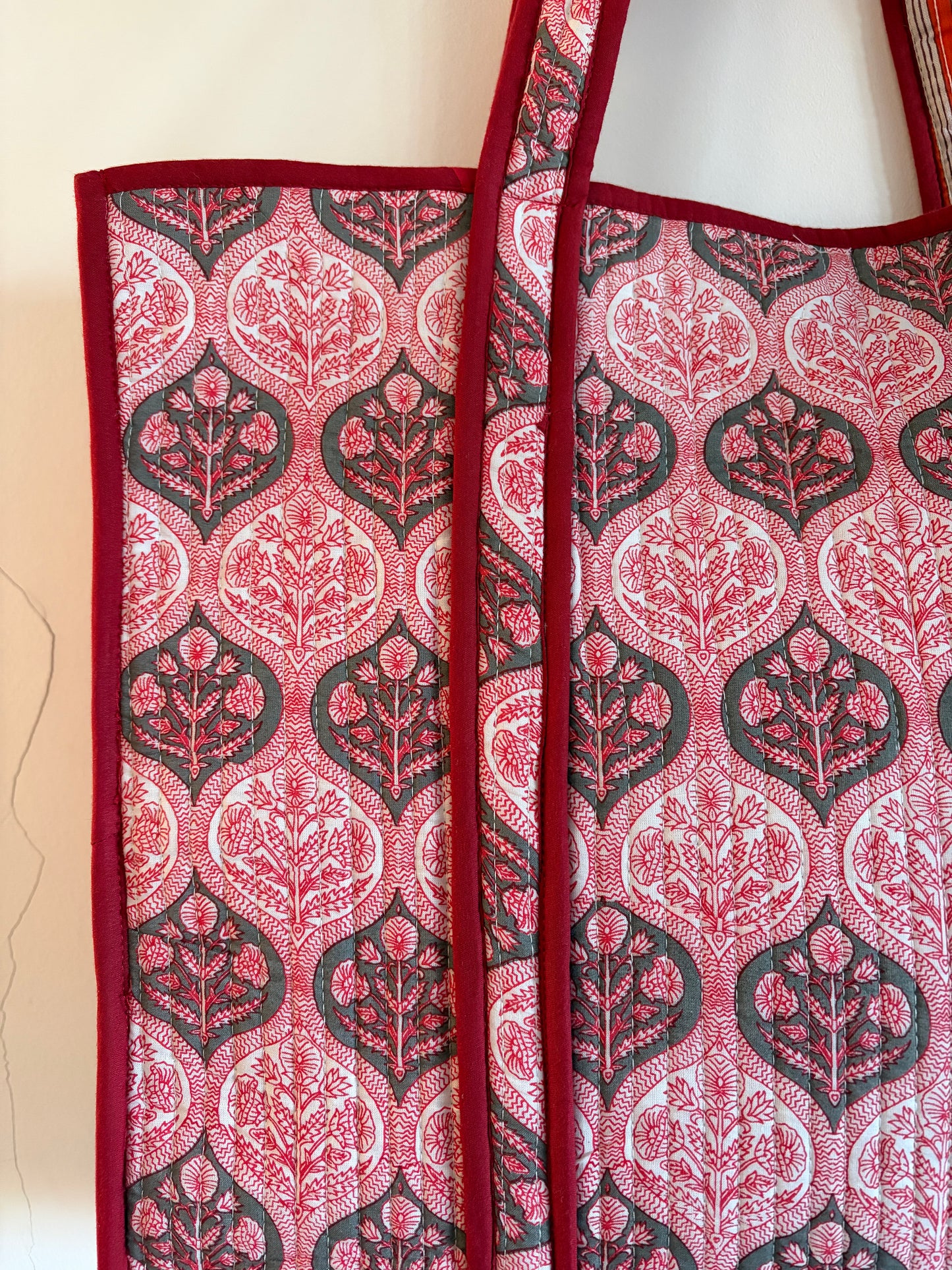 Close-up of a red and black patterned fabric bag with a white background