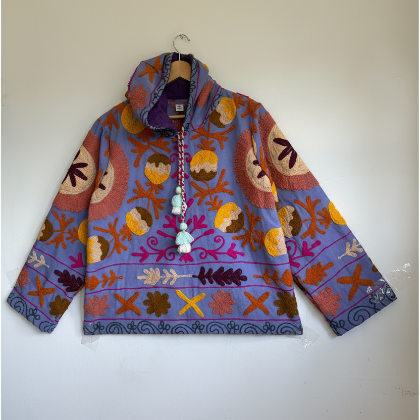 A colorful patterned jacket with a high collar and decorative tassel. 