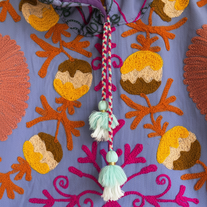 A colorful patterned jacket with a high collar and decorative tassel. 