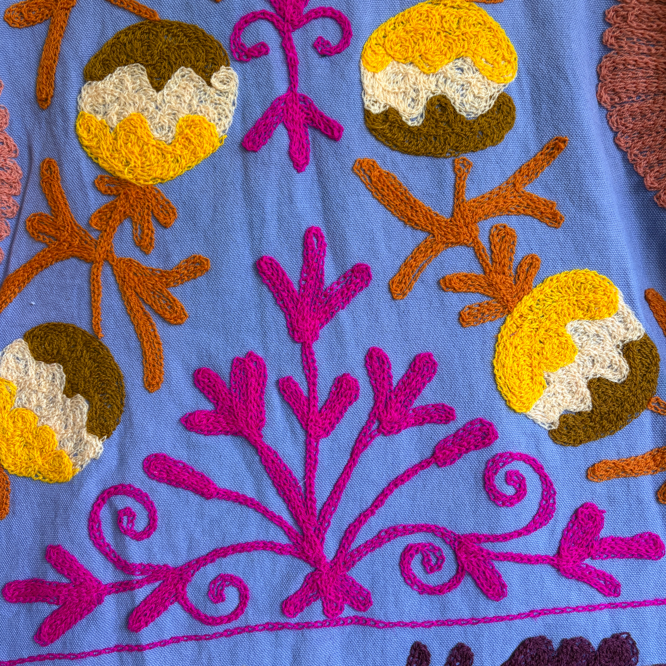A colorful patterned jacket with a high collar and decorative tassel. 