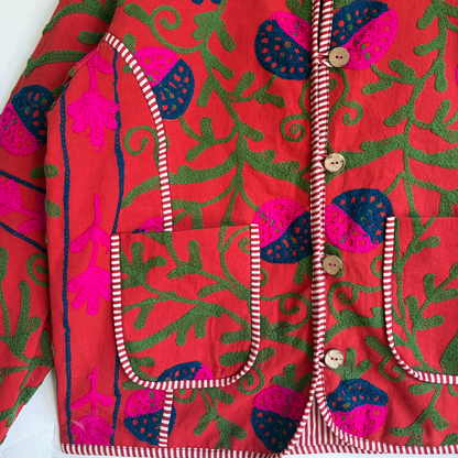 A red Suzani Embroidery jacket with a colorful floral and butterfly pattern. 