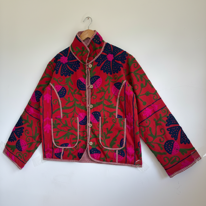 A red Suzani Embroidery jacket with a colorful floral and butterfly pattern. 