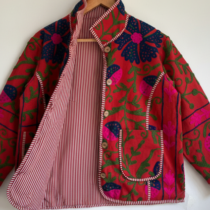 A red Suzani Embroidery jacket with a colorful floral and butterfly pattern. 