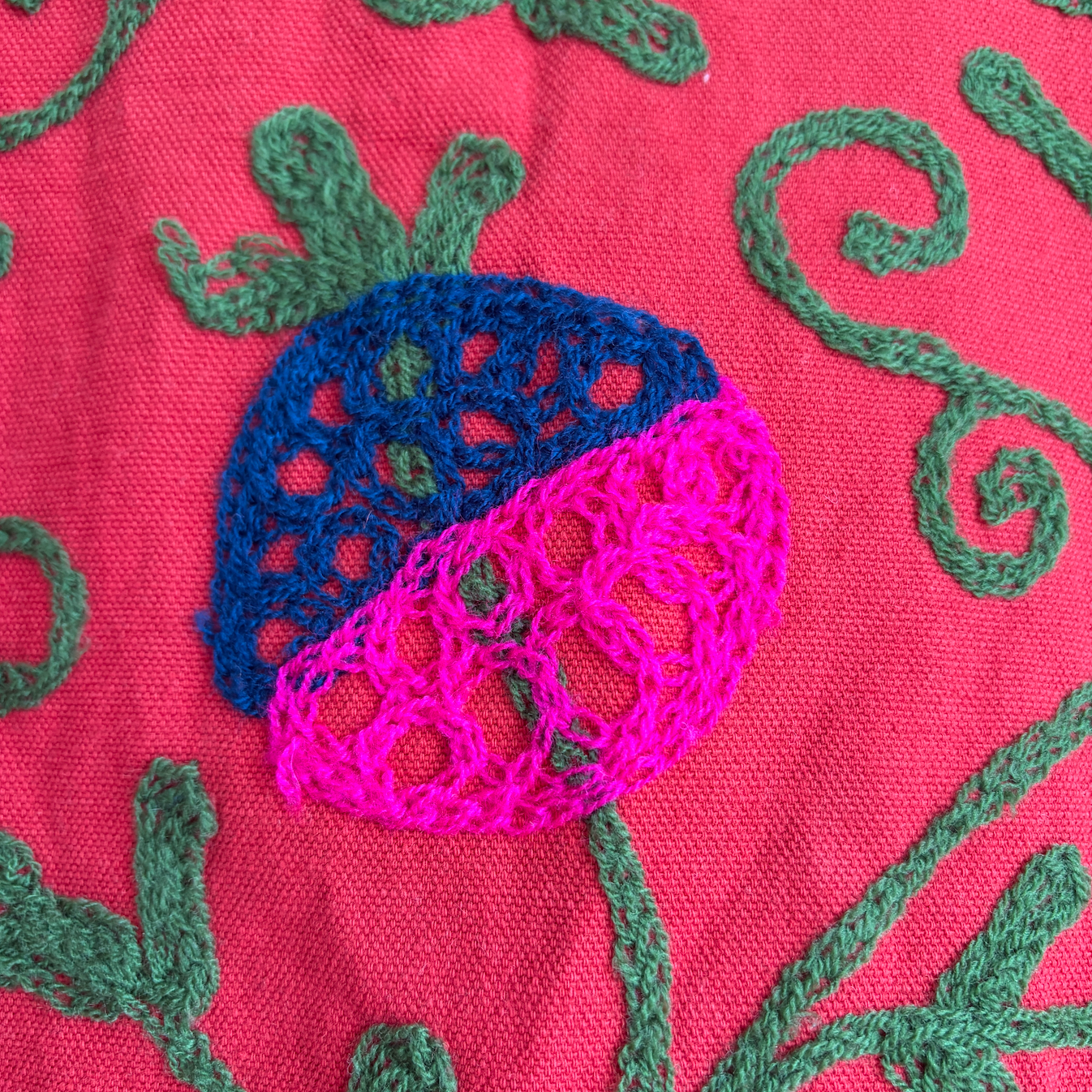 A red Suzani Embroidery jacket with a colorful floral and butterfly pattern. 