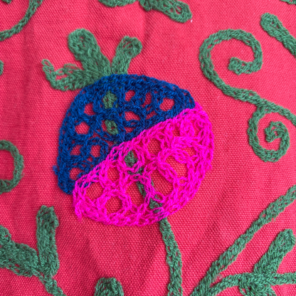 A red Suzani Embroidery jacket with a colorful floral and butterfly pattern. 