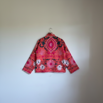 A coral pink embroidered jacket with floral and scroll patterns. 