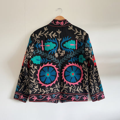 Embroidered fabric with colorful floral patterns on a plain background