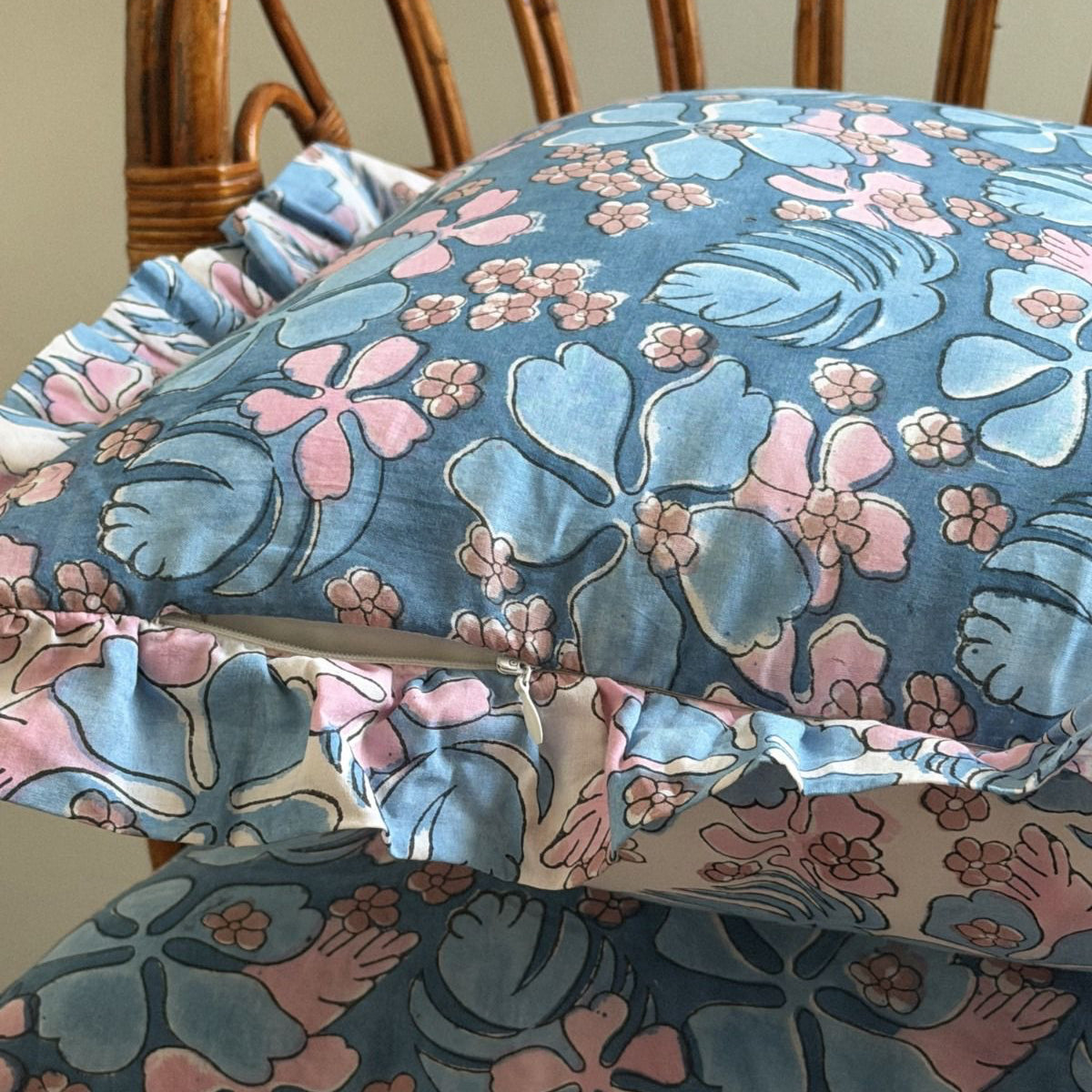 Blue floral pillowcase with pink and light blue tropical flowers and ruffled edges. 