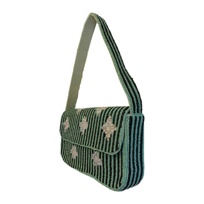 Green and black striped handbag with decorative elements on a white background