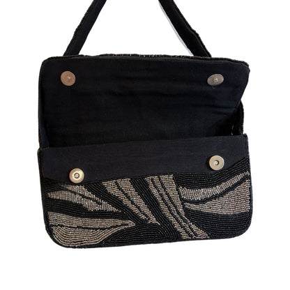 Black handbag with beaded leaf pattern on a white background