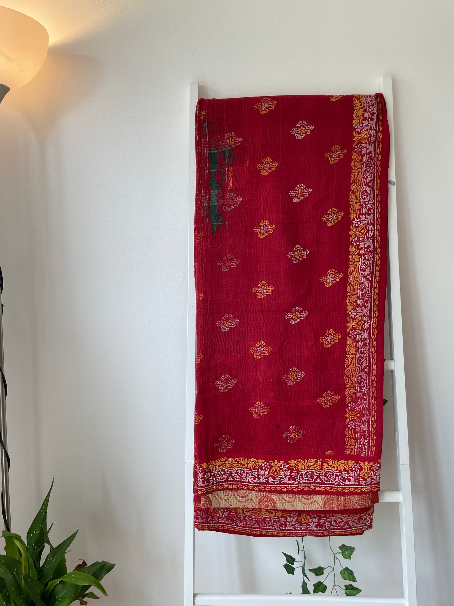 Red saree with gold patterns vintage kantha bed throw. 